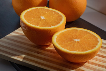 halves of juicy orange on a background of whole oranges