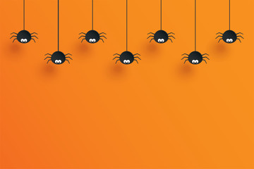 Halloween with hanging spiders for decoration and orange background space for text.