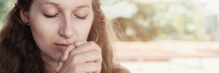 Young teen woman praying with eyes closed, hope concept, online home church