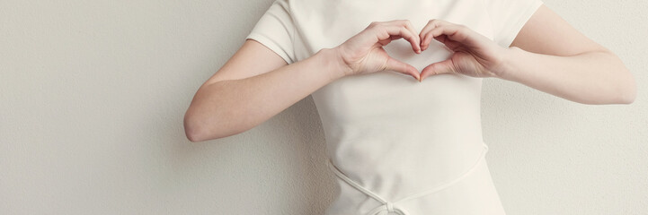 Happy Asian young woman making her hands in heart shape, heart health insurance, social responsibility, donation, happy charity volunteer, hope, world heart day, International Day of Sign Languages