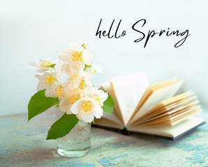 Hello Spring. Jasmine flowers and book. beautiful artistic image of spring season. romantic scene with book and white Jasmine flowers. soft selective focus, close up.