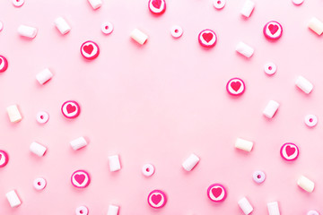 Delicious candies and marshmallows on pink background.