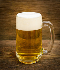 glass of beer on wooden background