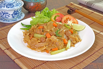 Noodles : Vegetarian stir fried flat noodle with black soy sauce, tofu, carrots and green vegetables. Chinese vegetarian food for vegetarian festival. Thai style stir fry flat noodle. (Pad See Ew)