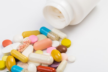 Assorted pharmaceutical medicine pills, tablets and capsules.Heap of assorted various medicine tablets and pills different colors on white background. Top view.Copy space