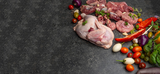 Different types of raw meat: beef, chicken, pork, turkey gilberts with vegetables and spices for cooking. Panoramic, horizontal banne. Copy space.