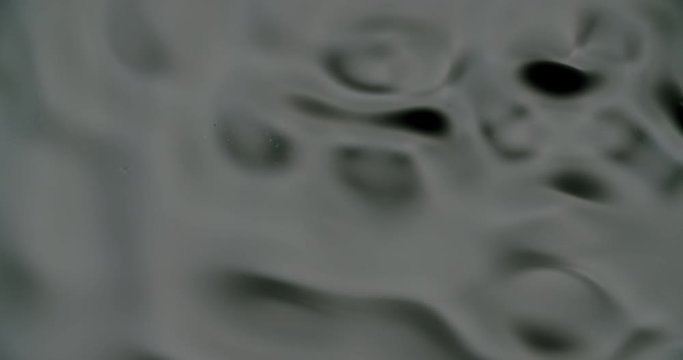 Water forming strange shapes in slow-motion. Static macro shot.