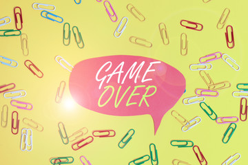 Handwriting text Game Over. Conceptual photo A situation in a particular sport that reach his finals or ending Flat lay above empty paper with copy space and colored paper clips