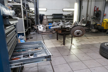 Open drawer rack with tools for repair and maintenance of vehicles in a car repair workshop. Auto service industry.