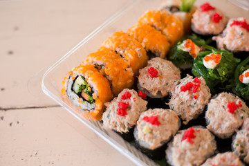 Mix japanese sushi rolls in take away package.