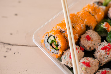 Mix japanese sushi rolls in take away package.