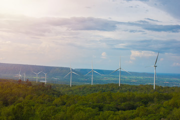 Beautiful landscape view of wind power turbine among mountain hill with blue sky in the early morning, Wind turbines on sunny morning, Windmills for electric power production, Green energy concept.