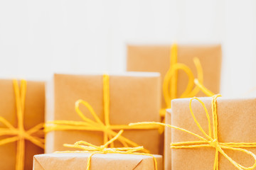 Holidays present collection. Closeup of beige paper gift boxes over white background. Copy space.