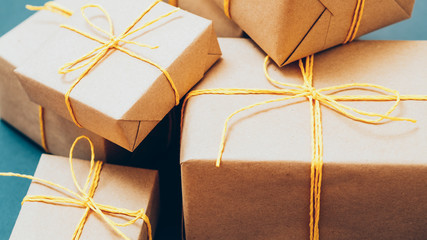 Online shopping. Goods delivery. Cropped closeup of beige paper boxes pile on blue background.
