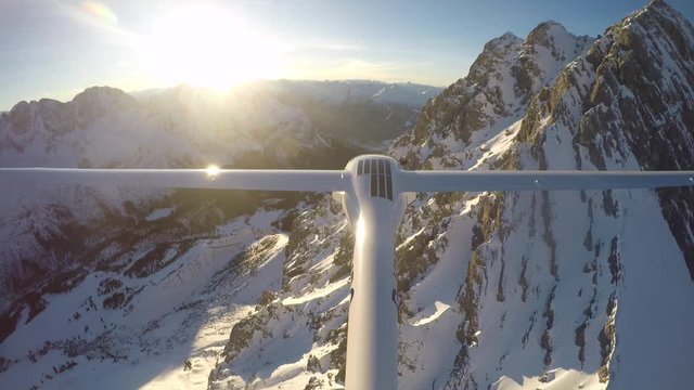 Glider Flying over Mountains on a sunny day in the alps of Tyrol.