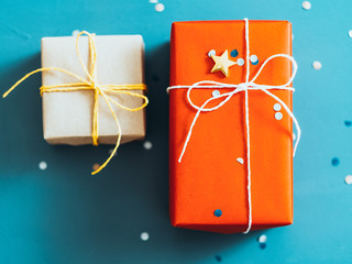 Romantic winter holidays. Flat lay of two gift boxes, star and round shape glitter on teal blue...