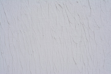 Part of the texture of a white wall decorated with decorative putty