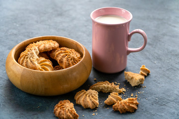fresh cookies and milk in a pink mug on a gray background