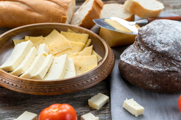 Cheese and bread on a wooden background