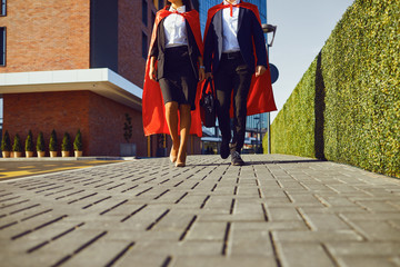 Business people super heroes walk along the city street.