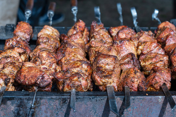 Grilled kebab cooking on metal skewer closeup. Roasted meat cooked at barbecue. BBQ fresh beef meat chop slices. Traditional eastern dish, shish kebab