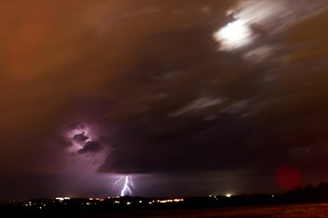 Lightening strike with blurred movement fast clouds and moon light