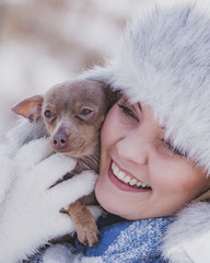 Woman playing with dog during winter