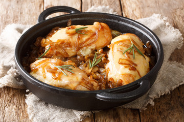 Baked chicken onion breast with cheese in a spicy wine sauce close-up in a pan. horizontal