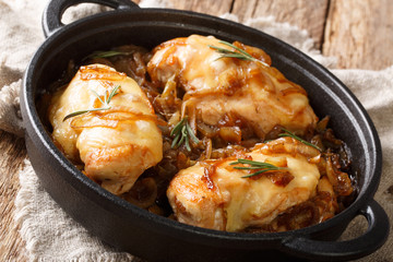 French chicken onion fillet cooked with gruyere cheese and spicy wine sauce close-up in a pan. horizontal
