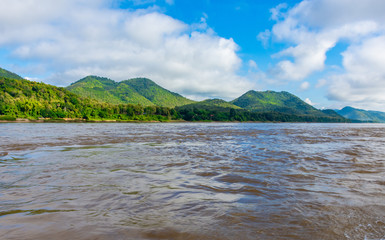 Beautiful green hills landscape with boat and rivers on blue sky background. decoration image contain certain grain noise and soft focus.