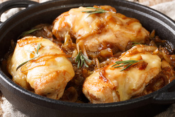 Baked chicken onion fillet with gruyere cheese and spicy sauce closeup in a pan. horizontal