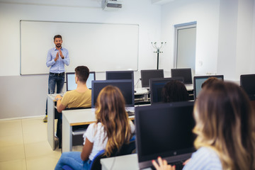 College students sitting in a classroom, using computers during class.