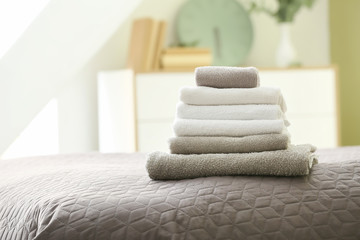 Stack of clean towels on bed
