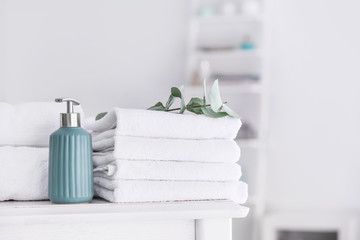 Soft clean towels with soap on table in bathroom