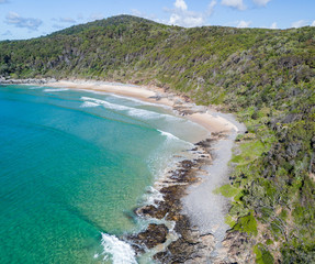 Spectacular aerial panorama of a cove with ocean and white sand beach. Beautiful little hidden secret paradise for a holiday gateway. Noosa National Park, Queensland Australia