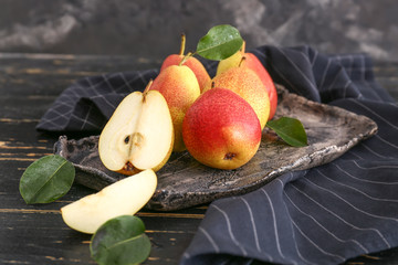 Plate with tasty fresh pears on dark table