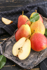 Plate with tasty fresh pears on dark table