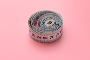 Measuring tape on color background