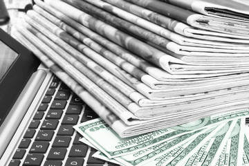 Stack of Newspapers, Money and Laptop. Journals with Headlines and Articles and One Hundred Dollar Bills on Keyboard of Notebook. Magazines with News, Computer and American Currency, Business Concept