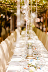 Beautifully decorated wedding ceremony location under a large oak tree, wide view.