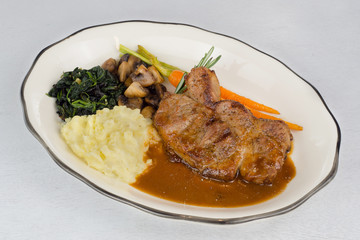Pork Steak Gravy Sauce with Mashed Potatoes,Spinach,Mushroom and Baby Carrot On White Wood Table
