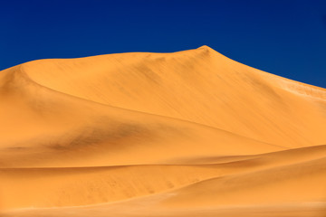 Namib Desert, sand dune mountain with beautiful blue sky, hot summer day. Landscape in Namibia, Africa. Travelling in the Namibia desert. Yellow sand hills. Landscape in Namibia, Africa.