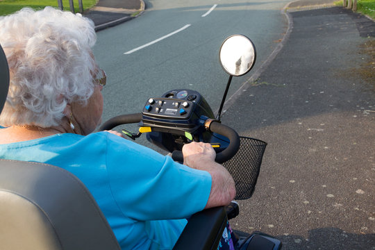 Elderly woman on a mobility scooter. 