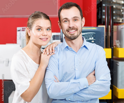 Young loving couple standing in specialty workshop of safes