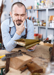 Annoyed workman in repair furniture workshop