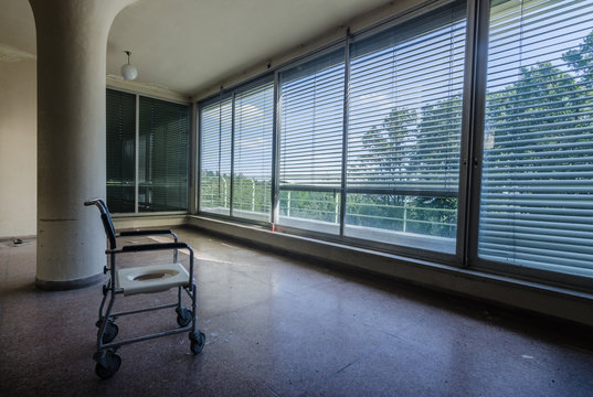 leibstuhl und runde saeule mit vielen fenstern in einem krankenhaus