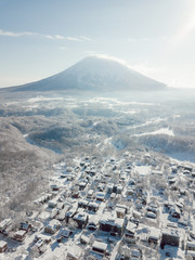 Winter in Niseko, Japan. A blue bird kind of day at Grand Hirafu, Niseko Ski Resort. Photos were taken with a drone overlooking the Grand Hirafu area with views of Mt. Niseko-Annupuri. and Mt. Yotei.