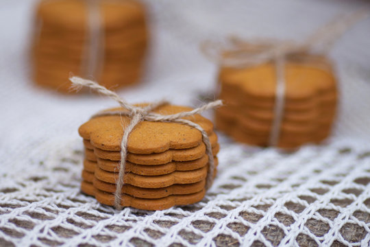 Gingerl cookies on  table in rustic style. Baking is folded in a row on each other and tied with natural braid. Close up image