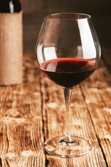 Red wine in a tasting glass on the background of the bottle.