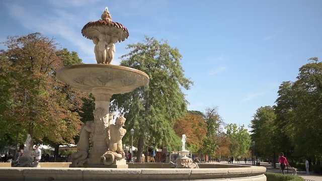 Electric scooter passing around a fountain in El Retiro Park